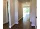 Hallway view with beautiful laminate flooring leading to an open living area and natural light at 10540 Sw 49Th Avenue Rd, Ocala, FL 34476