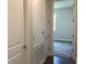 Bright hallway featuring white trim, doors, and neutral wall paint with wood-look flooring at 10540 Sw 49Th Avenue Rd, Ocala, FL 34476