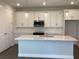 Bright kitchen features white cabinetry, an island with sink, and stainless steel appliances at 10540 Sw 49Th Avenue Rd, Ocala, FL 34476