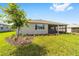 Well-maintained backyard with green lawn, mulch bed and landscaping leading to a screened-in porch at 10625 Sw 98Th Pl, Ocala, FL 34481