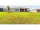 Large grassy backyard has manicured shrubbery and a screened porch at 10625 Sw 98Th Pl, Ocala, FL 34481