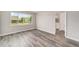Bright bedroom features grey wood flooring and a large window with an exterior view at 10625 Sw 98Th Pl, Ocala, FL 34481