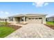 The exterior of this home showcases a paver driveway and a front lawn with mulch at 10625 Sw 98Th Pl, Ocala, FL 34481