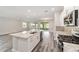 Kitchen featuring a large island, white cabinets, gray backsplash, and stainless steel appliances at 10625 Sw 98Th Pl, Ocala, FL 34481