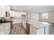 Modern kitchen with white cabinets, gray backsplash, and a large island with granite countertops at 10625 Sw 98Th Pl, Ocala, FL 34481