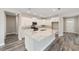 Open kitchen featuring white cabinets, gray backsplash, and a large island with granite countertops at 10625 Sw 98Th Pl, Ocala, FL 34481