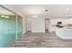 Open-concept living area with gray wood floors, a chandelier, and access to the kitchen and sliding glass doors at 10625 Sw 98Th Pl, Ocala, FL 34481