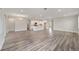 Spacious living room featuring gray wood floors, light gray walls, and an open-concept kitchen at 10625 Sw 98Th Pl, Ocala, FL 34481