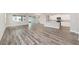 Open-concept living room featuring gray wood floors, light gray walls, and sliding glass doors at 10625 Sw 98Th Pl, Ocala, FL 34481