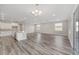 Living room with gray wood floors and kitchen island with stainless steel appliances at 10625 Sw 98Th Pl, Ocala, FL 34481
