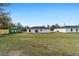 Expansive backyard view featuring a well-maintained lawn and neighboring houses with a fence at 11200 Sw 131 Ter, Dunnellon, FL 34432