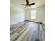 This bedroom has wood-look flooring, a ceiling fan, and natural light at 12282 Sw 80Th St, Dunnellon, FL 34432