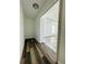 Hallway with wood-look floors leading to a bedroom featuring natural light at 12282 Sw 80Th St, Dunnellon, FL 34432