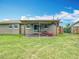 A covered backyard patio with a lawn mower and access to the grassy backyard and fence at 1520 Ne 17Th Ave, Ocala, FL 34470