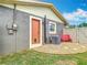 A landscaped backyard featuring an air conditioner, pebble ground cover, and a red bench at 1520 Ne 17Th Ave, Ocala, FL 34470