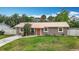 Well-kept house has a metal roof, green lawn, and concrete pathway at 1520 Ne 17Th Ave, Ocala, FL 34470