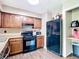 This kitchen features wood cabinets, neutral counters, black appliances and vinyl floors at 1520 Ne 17Th Ave, Ocala, FL 34470
