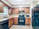 Cozy kitchen features wooden cabinets, black appliances, and wood-look flooring at 1520 Ne 17Th Ave, Ocala, FL 34470