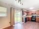 Eat-in kitchen with wood cabinets, black appliances and sliding glass doors to the backyard at 1520 Ne 17Th Ave, Ocala, FL 34470