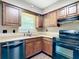 This is a kitchen featuring wood cabinets, laminate counters, and black appliances at 1520 Ne 17Th Ave, Ocala, FL 34470
