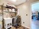 Convenient laundry room featuring a utility sink, modern washer, and shelving for storage at 1520 Ne 17Th Ave, Ocala, FL 34470