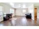 Spacious living room featuring wood floors, a desk, and abundant natural light at 1520 Ne 17Th Ave, Ocala, FL 34470