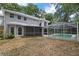 Backyard with screened-in pool and view of gray siding and arched windows on the house at 1628 Se 29Th Ter, Ocala, FL 34471