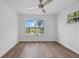 Bright bedroom featuring wood floors, a ceiling fan, and a scenic lake view from the window at 1628 Se 29Th Ter, Ocala, FL 34471