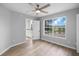 The bedroom features wood-look floors, a ceiling fan, and a window view of the lake at 1628 Se 29Th Ter, Ocala, FL 34471
