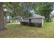 A charming view showcases the side of a gray home with mature trees and landscaping at 1628 Se 29Th Ter, Ocala, FL 34471