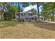 A beautiful two-story home with gray siding, a porch, and a well-manicured yard sits among the trees at 1628 Se 29Th Ter, Ocala, FL 34471