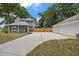 A view of the gray house features a manicured lawn, and a spacious driveway at 1628 Se 29Th Ter, Ocala, FL 34471