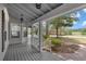 Charming covered front porch with wooden flooring overlooking a serene landscape at 1628 Se 29Th Ter, Ocala, FL 34471