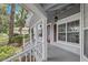 A covered porch with an ornate glass door and gray wood trim highlights the home's inviting entryway at 1628 Se 29Th Ter, Ocala, FL 34471