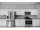 Bright kitchen with stainless steel refrigerator and range, plus modern white cabinetry at 1628 Se 29Th Ter, Ocala, FL 34471