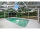 This backyard pool has a screen enclosure, concrete patio, and lush landscaping at 1628 Se 29Th Ter, Ocala, FL 34471