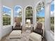Sitting area furnished with chairs, ottomans, and a small table with views from large windows at 1628 Se 29Th Ter, Ocala, FL 34471