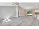 Open-concept living space with new gray flooring that adjoins the kitchen and has sliding glass doors to a large backyard at 174 Pine Crse, Ocala, FL 34472