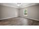 Spacious bedroom with tray ceiling, wood-look flooring, and natural light from the window at 176 Pine Crse, Ocala, FL 34472