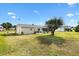 Expansive backyard with lush lawn, swing, and sunroom, providing ample space for outdoor activities at 17890 Se 96Th Ct, Summerfield, FL 34491