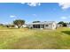 Large backyard with lawn, patio, and screened sunroom offering a serene outdoor living space at 17890 Se 96Th Ct, Summerfield, FL 34491