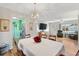 Bright dining area adjacent to the kitchen and living room, highlighted by a modern chandelier and hardwood floors at 17890 Se 96Th Ct, Summerfield, FL 34491