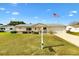 Charming single-story home featuring a well-manicured lawn, white siding, and an American flag in a sunny neighborhood at 17890 Se 96Th Ct, Summerfield, FL 34491