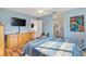 Spacious main bedroom with a TV, hardwood floors, ensuite bathroom, and a walk-in closet at 17890 Se 96Th Ct, Summerfield, FL 34491