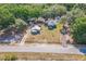 Aerial view showcases the property, detached structures, pool, and lush surrounding landscape at 1839 Cr 543A, Sumterville, FL 33585