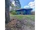 Back yard featuring an outdoor garden and patio, surrounded by trees at 1839 Cr 543A, Sumterville, FL 33585