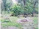 Backyard fire pit with log seating nestled amongst the trees at 1839 Cr 543A, Sumterville, FL 33585