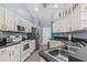 A bright kitchen with white cabinets, gray walls, and stainless steel appliances at 2698 Sw 186Th Ct, Dunnellon, FL 34432