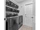 Modern laundry room with washer, dryer, storage, and tiled floors at 2698 Sw 186Th Ct, Dunnellon, FL 34432