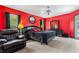 A modern main bedroom featuring red walls and elegant black furniture at 2698 Sw 186Th Ct, Dunnellon, FL 34432